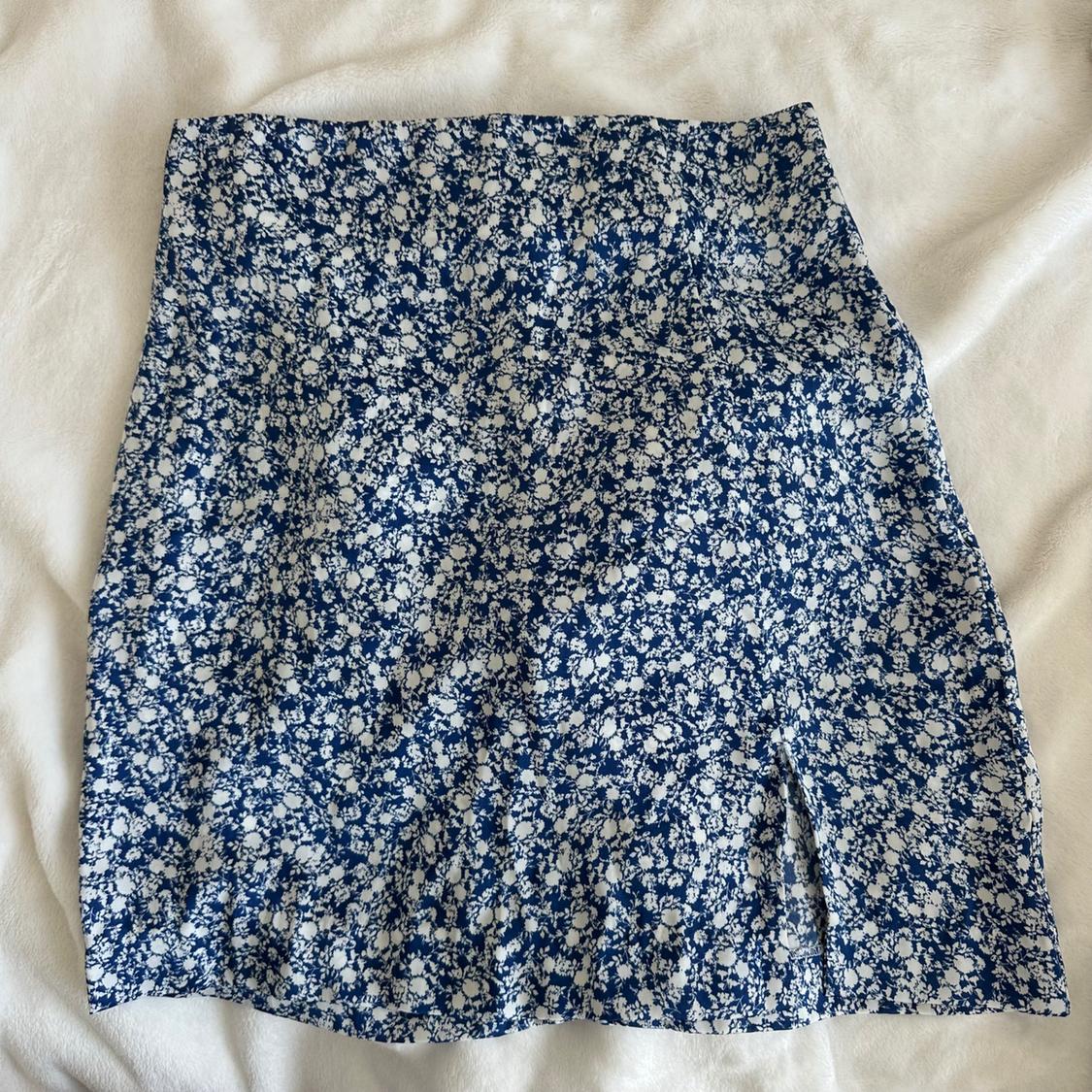 Short skirt with a blue and white floral print on a light background. Soft and lightweight fabric, ideal for a summery look.