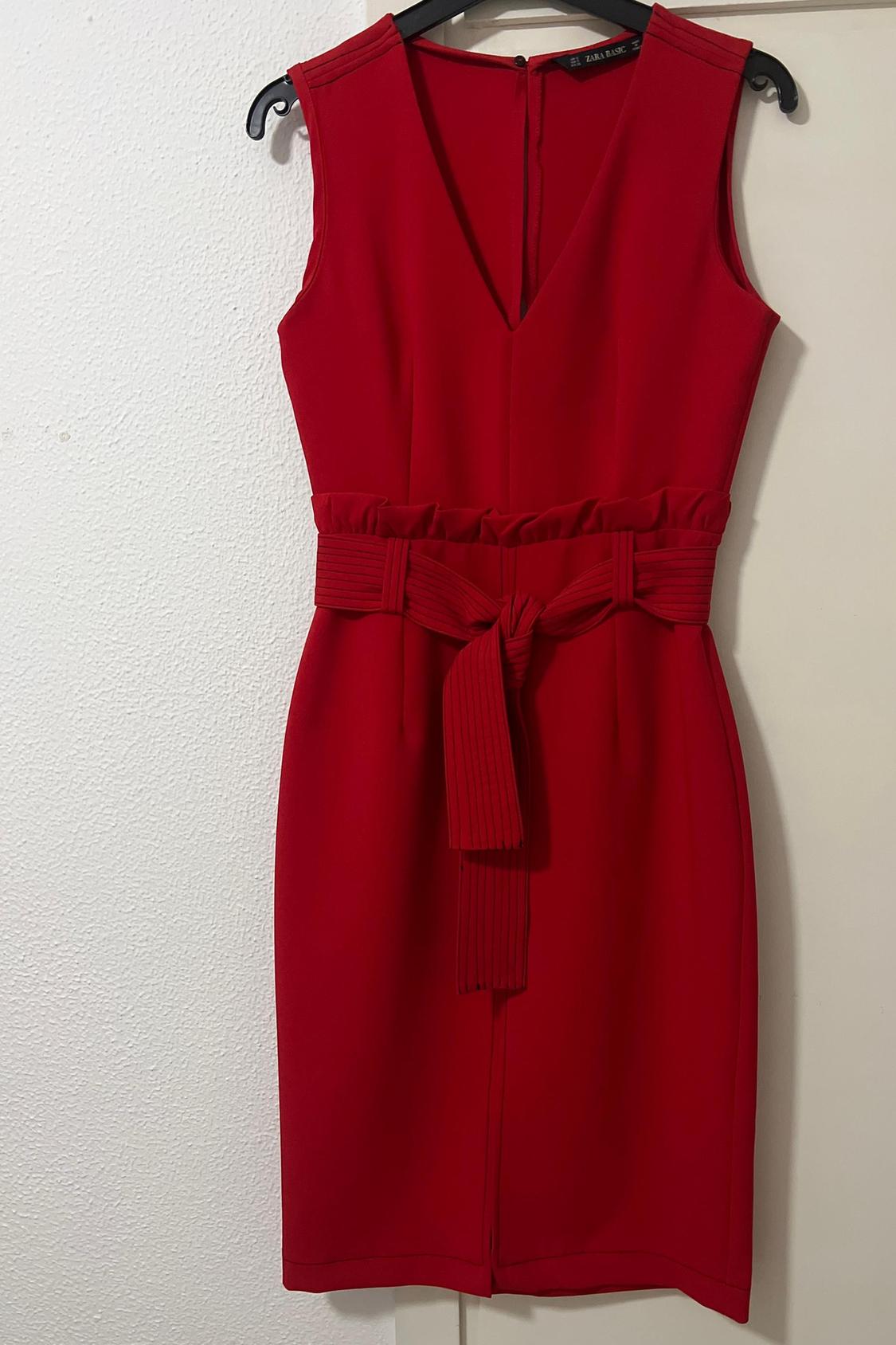 Front view of red sleeveless dress with tied belt.