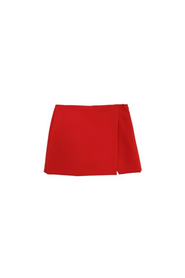 Red mini skirt with an asymmetrical design on a white background.
