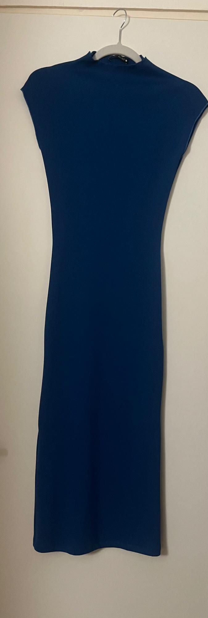 Sleeveless blue dress hanging on a hanger against a white background.