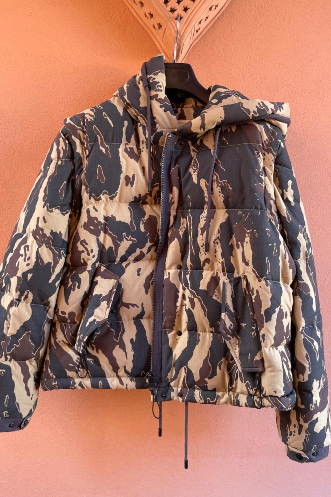 Front view of a padded jacket with camouflage print and hood, front pockets with flaps.