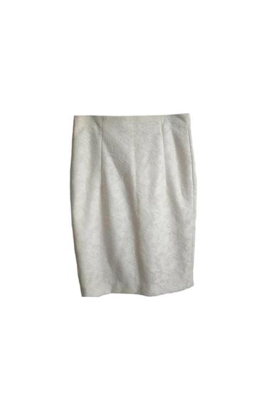 White lace skirt with a floral design on a white background. Straight cut and detailed texture.