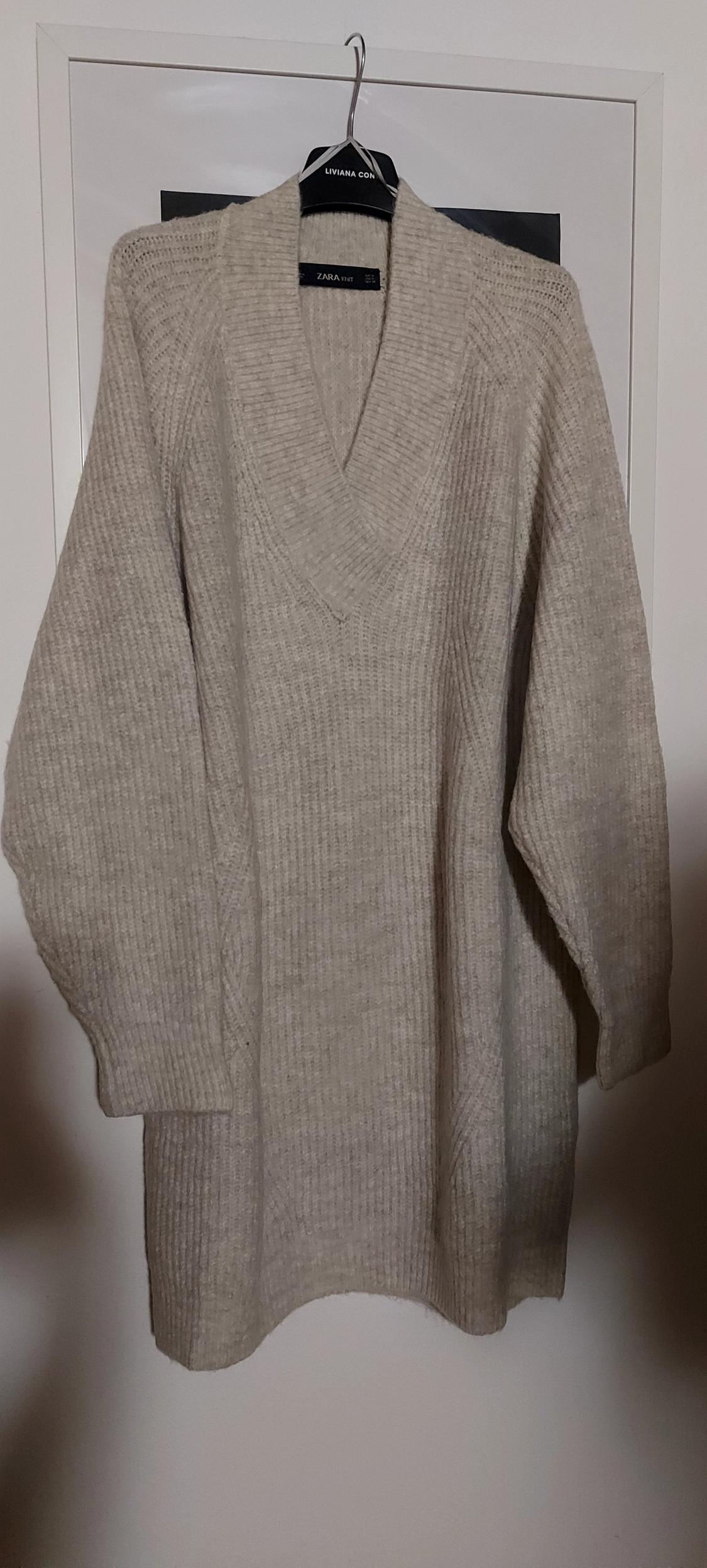 Front view of a beige V-neck, long-sleeved jumper
