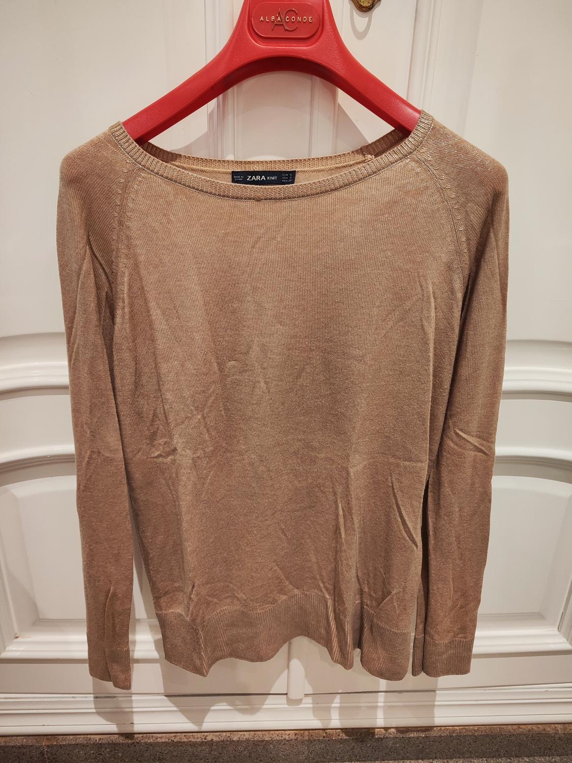 Front view of a beige jumper with a round neck and long sleeves.