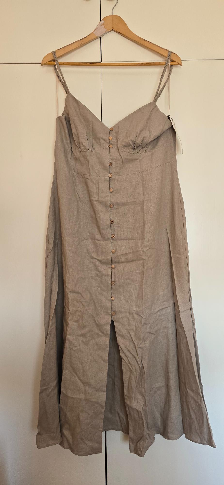 Beige maxi dress with braided straps, a V-neckline and front buttons, hanging on a wooden hanger against a white background.