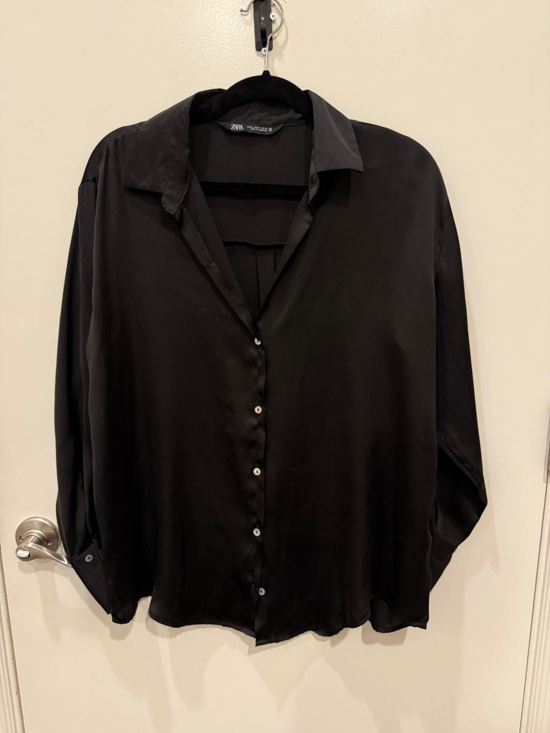 Front view of a black button-up shirt with a classic collar.