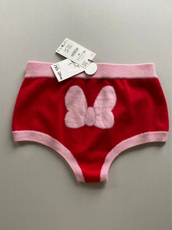 Red knickers with pink trim and a white bow design in the centre. Visible hang tags at the top.