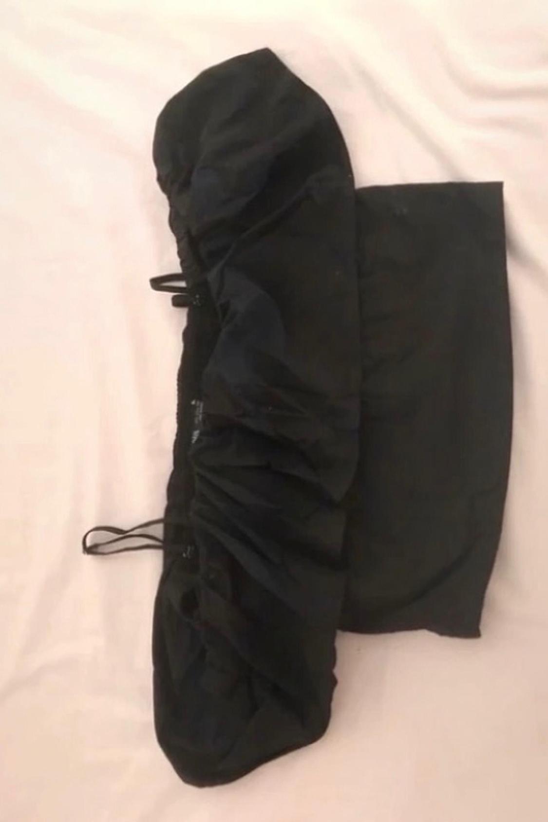 Detail of a black garment with elastic and visible seams.