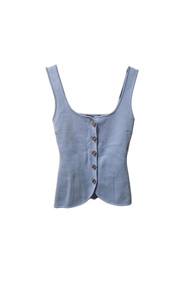 Light blue sleeveless top with a round neckline and metal button fastening on the front against a white background.