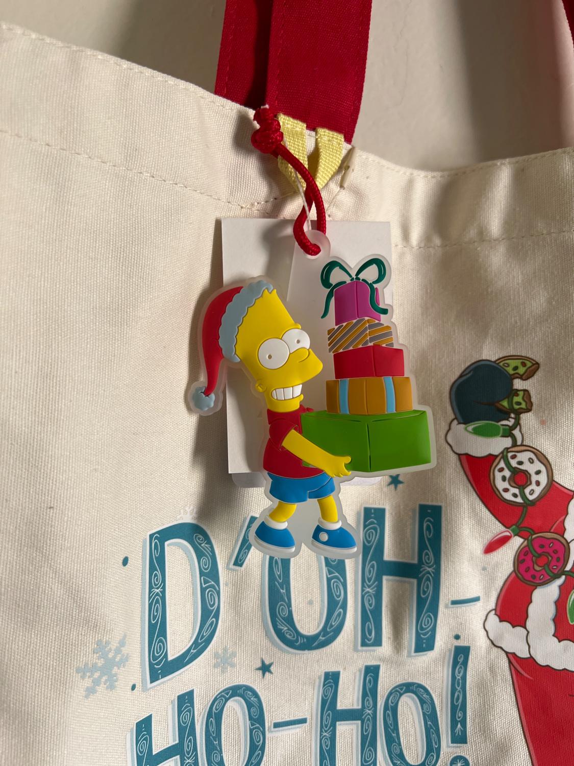 Fabric bag with red handle and Christmas design. Animated character figure with presents and "D'OH HO-HO!" text in blue.