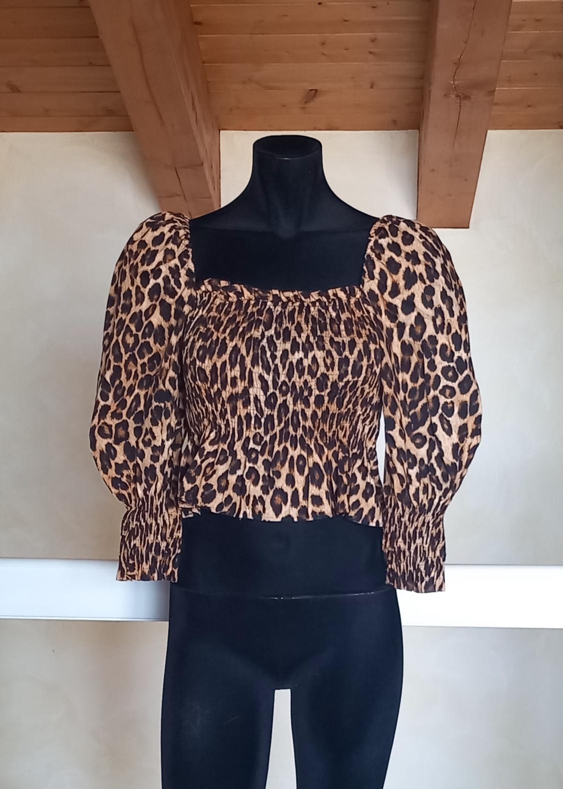 Μανεκέν με μπλούζα με animal print λεοπάρ, φουσκωτά μανίκια, σε περιβάλλον με ξύλινη οροφή.