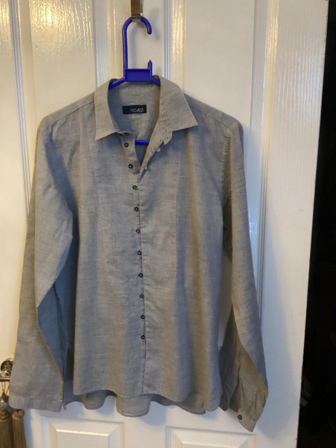 Front view of a grey shirt with a classic collar and central button fastening.