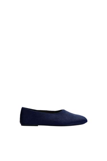 Dark blue flat shoe with a textured finish against a white background.