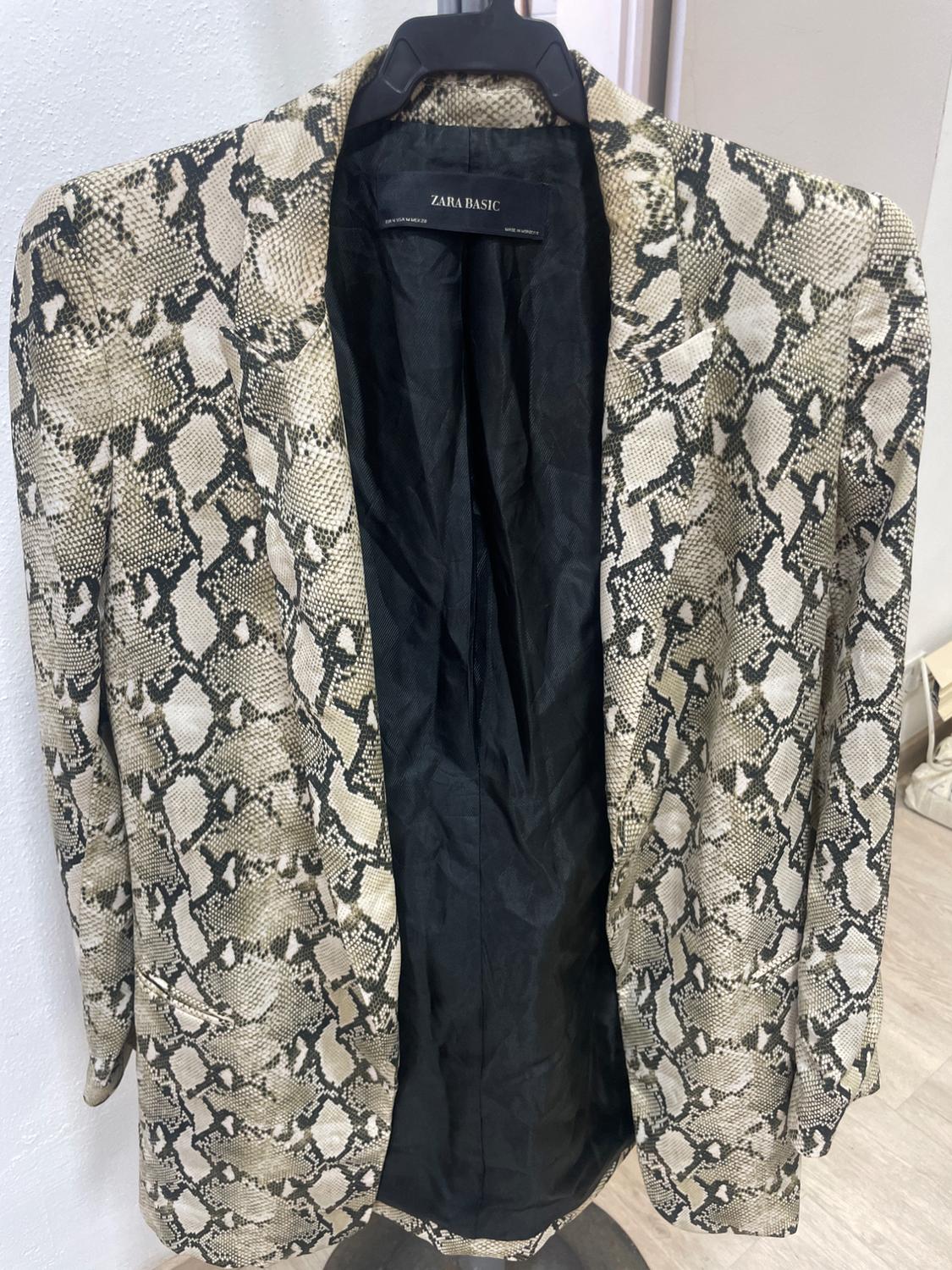 Snake print jacket in beige and black tones, hanging on a black hanger. Inside label: "ZARA BASIC".