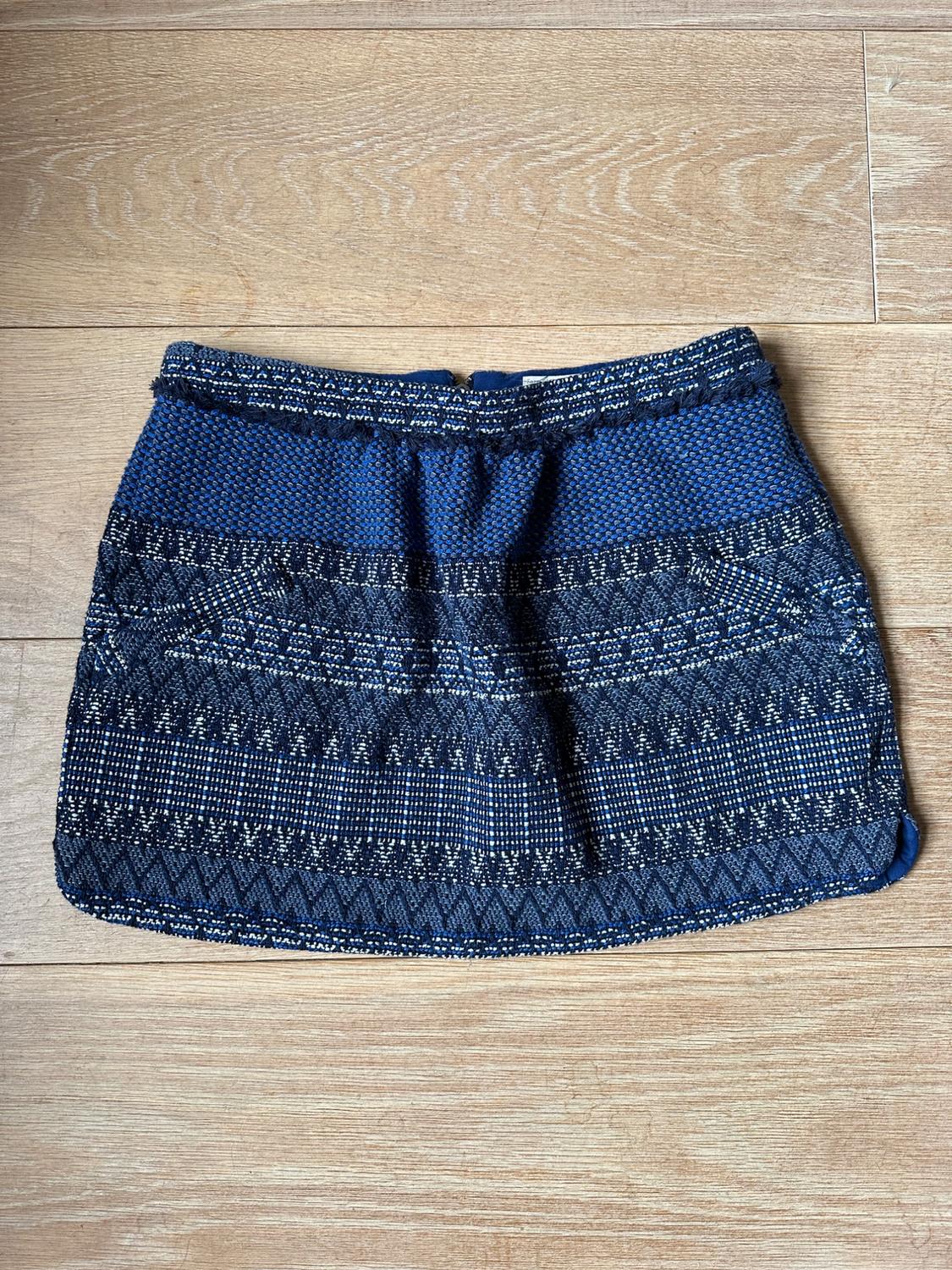Front view of a short skirt with a geometric print in blue and black tones.