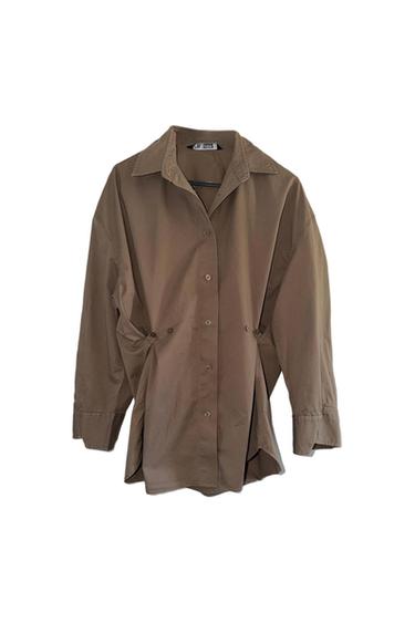 Brown long-sleeved shirt with front buttons and classic collar, hanging on a hanger against a white background.