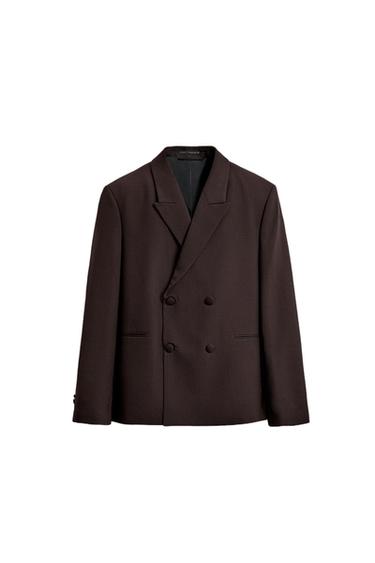Front view of a dark brown double-breasted jacket with peak lapels. Side pockets without flaps.