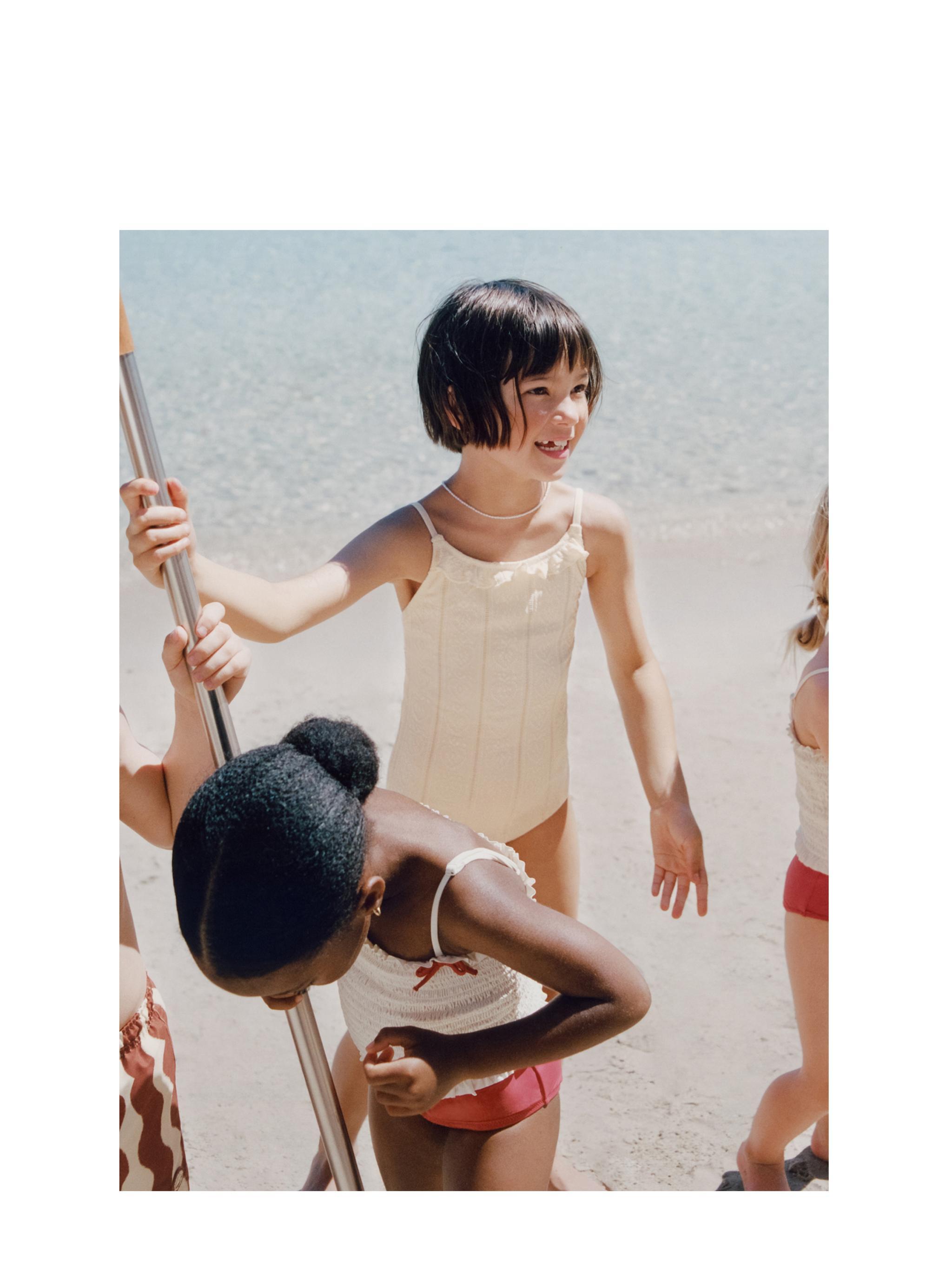 Жағажайда мөлдір бикини киген қыздар