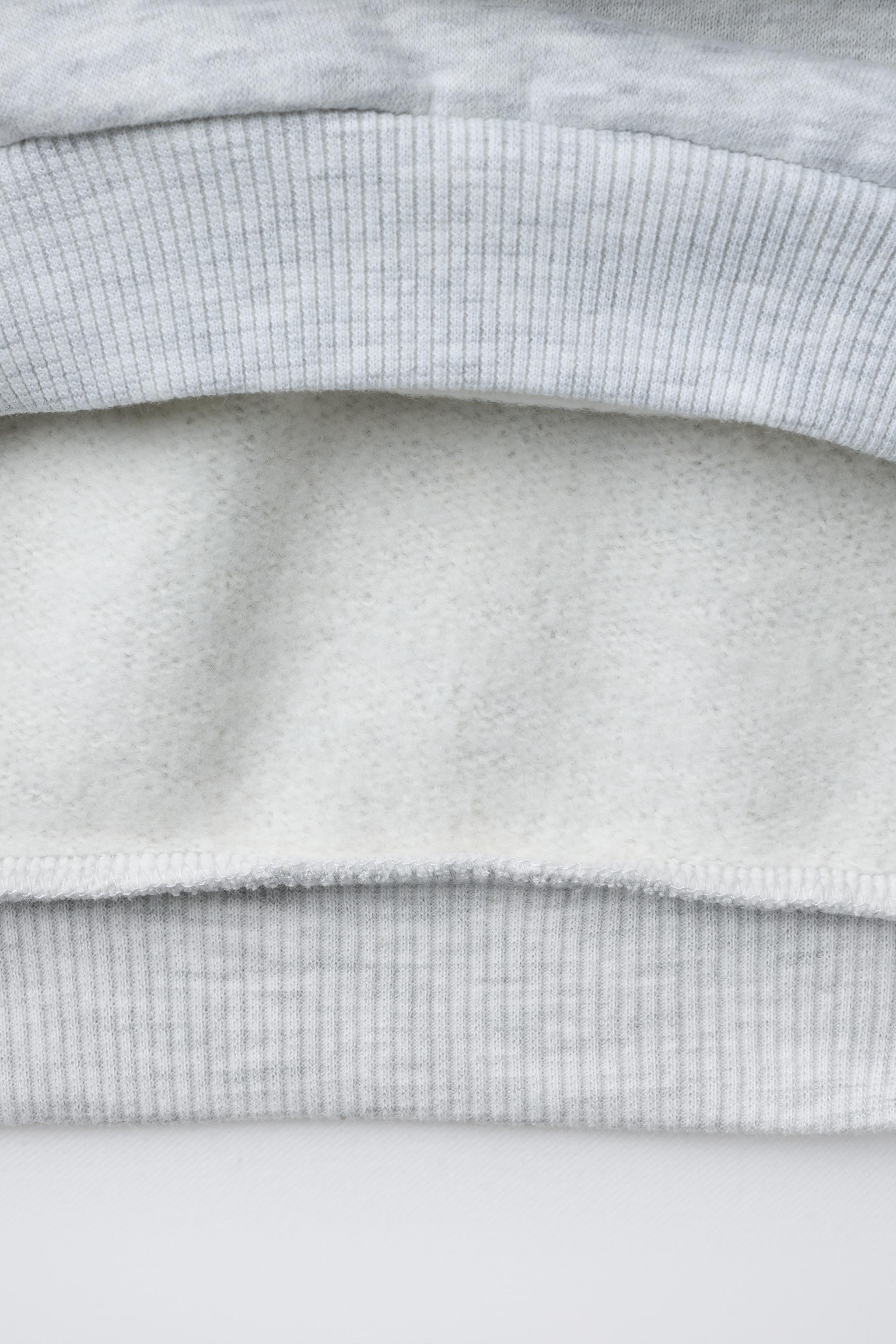 SWEAT À CAPUCHE ET INSCRIPTION