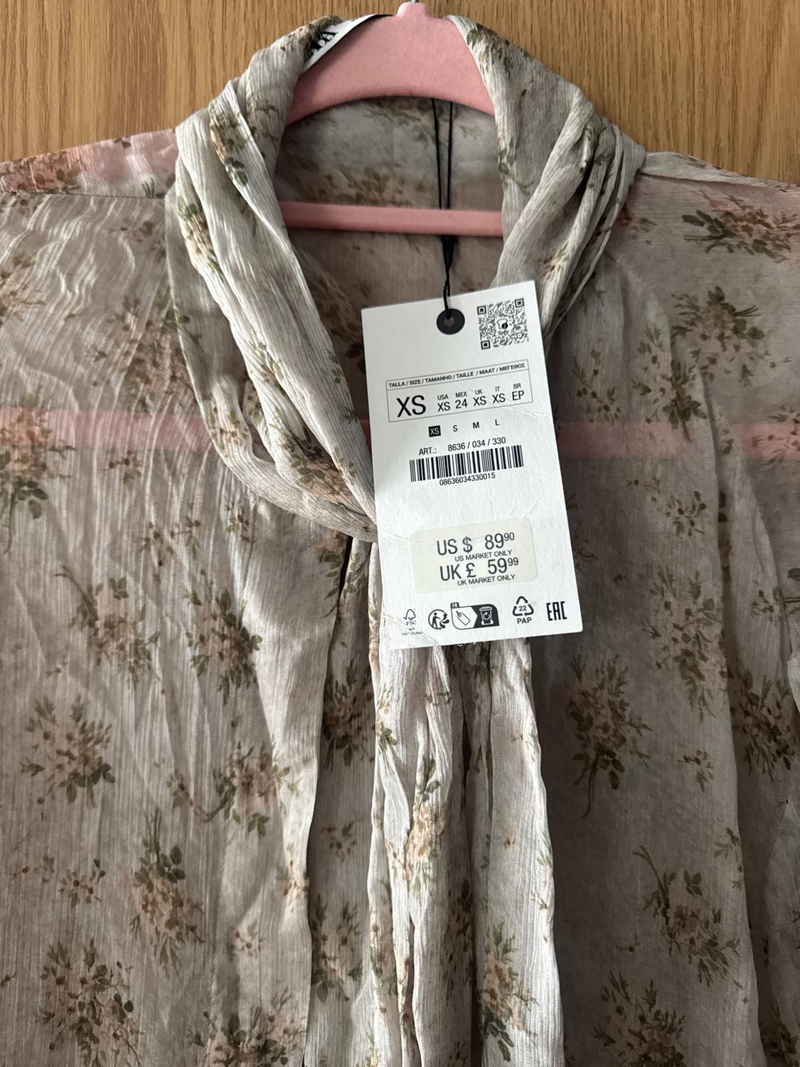 Sheer floral blouse with tie neck. Label: XS ART.: 8636 / 034 / 330 US $ 89.90 US MARKET ONLY UK £ 59.99 UK MARKET ONLY.