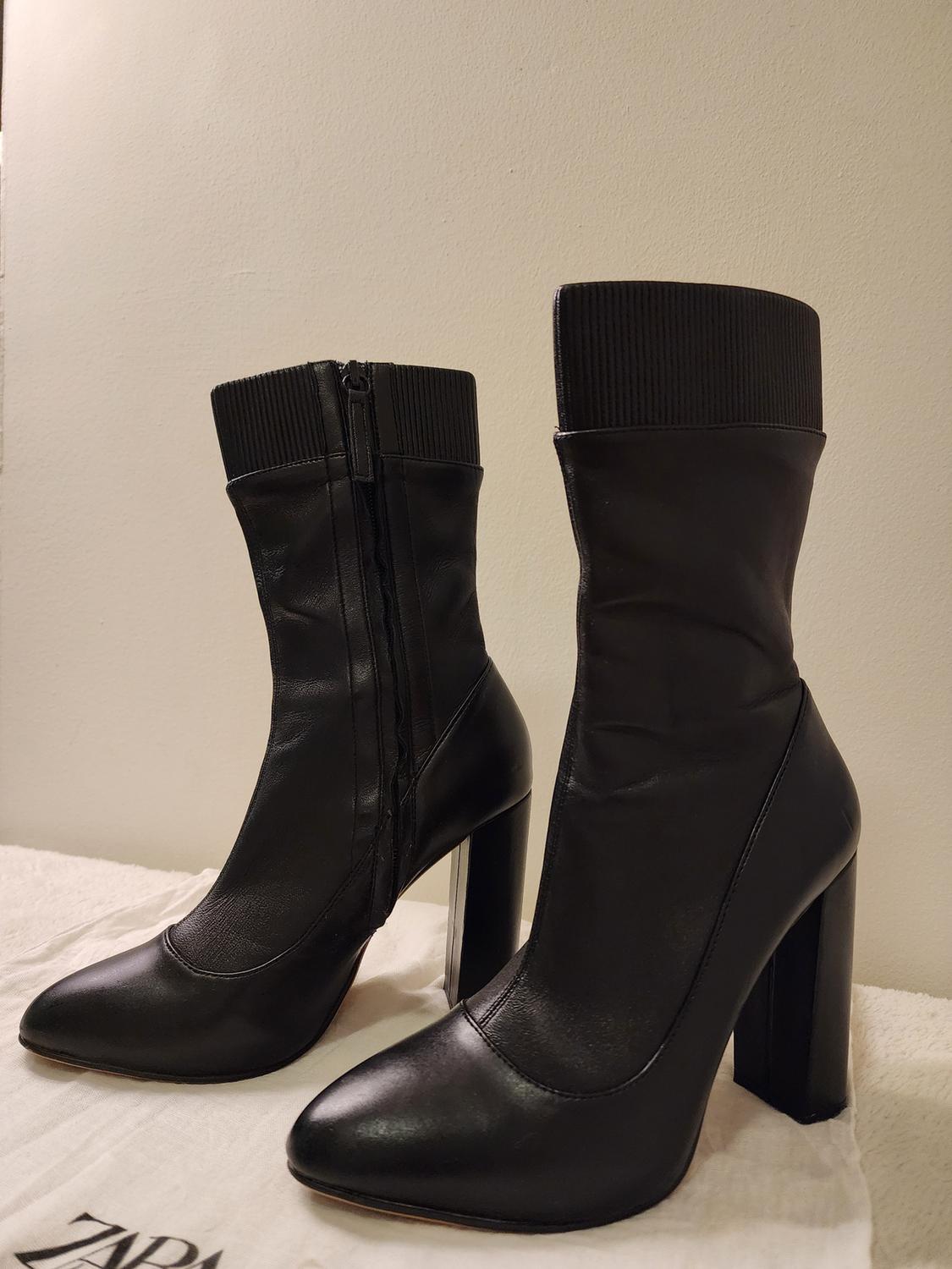 Black ankle boots with a high heel and side zipper.