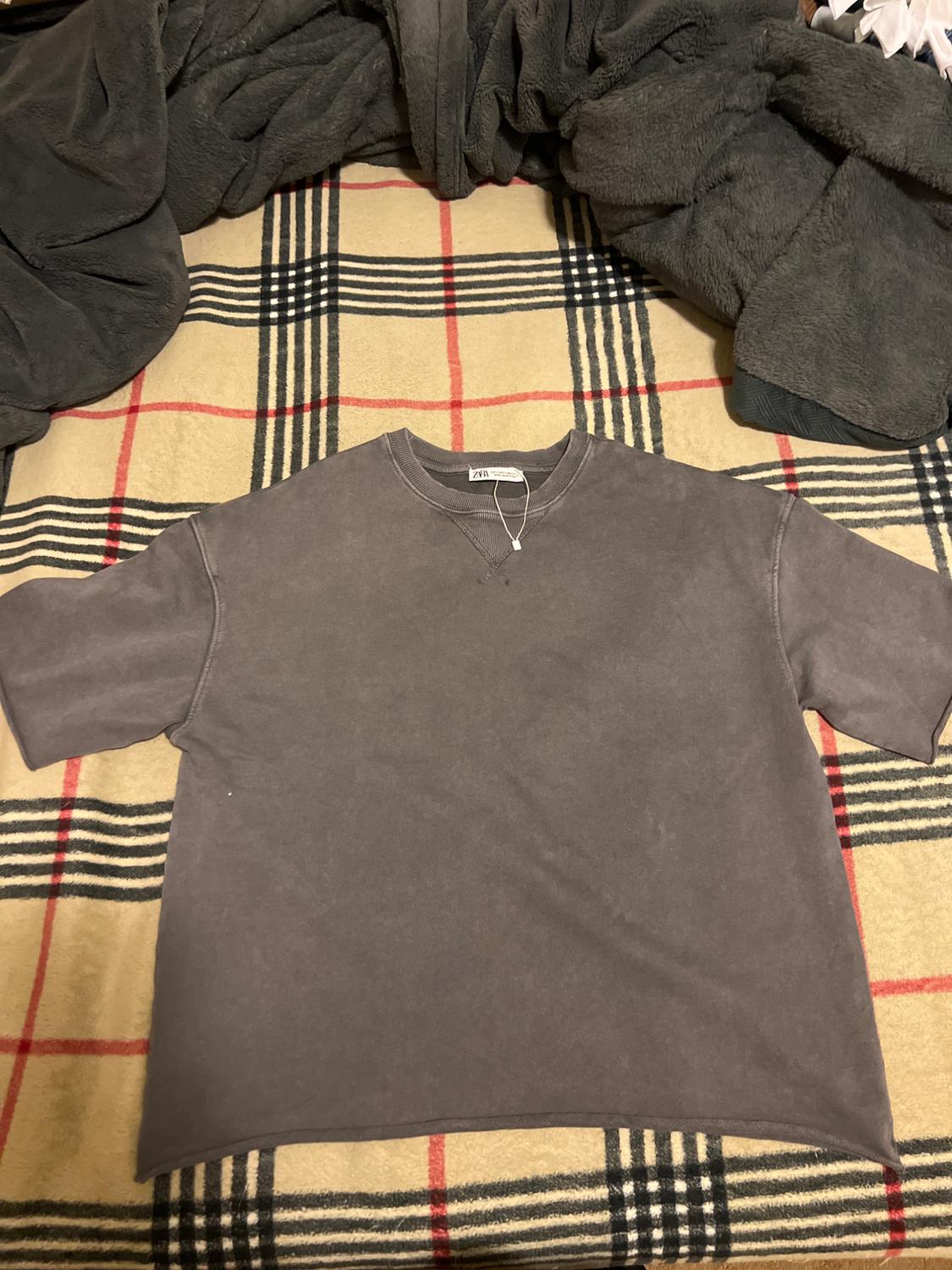 Front view of a gray t-shirt with a round neck and short sleeves.