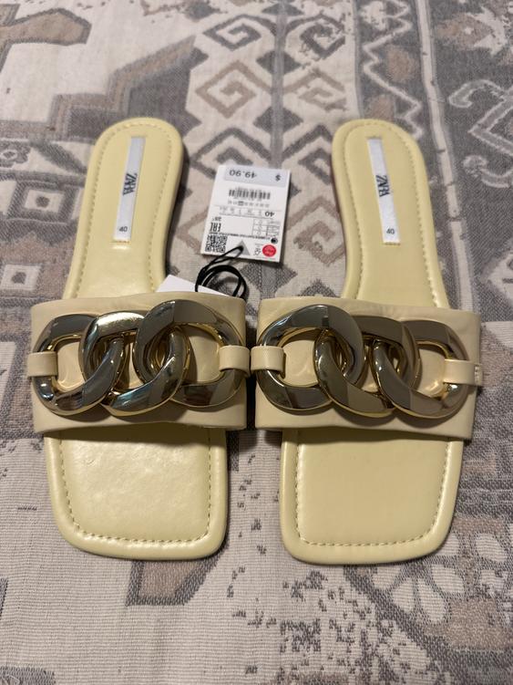 Beige sandals with gold links on geometric printed fabric. Visible tag with price of $49.90 and size 40.