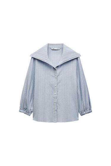 Light blue shirt with white stripes, wide collar, front buttons and sleeves with elasticated cuffs on a white background. Text: ZARA.
