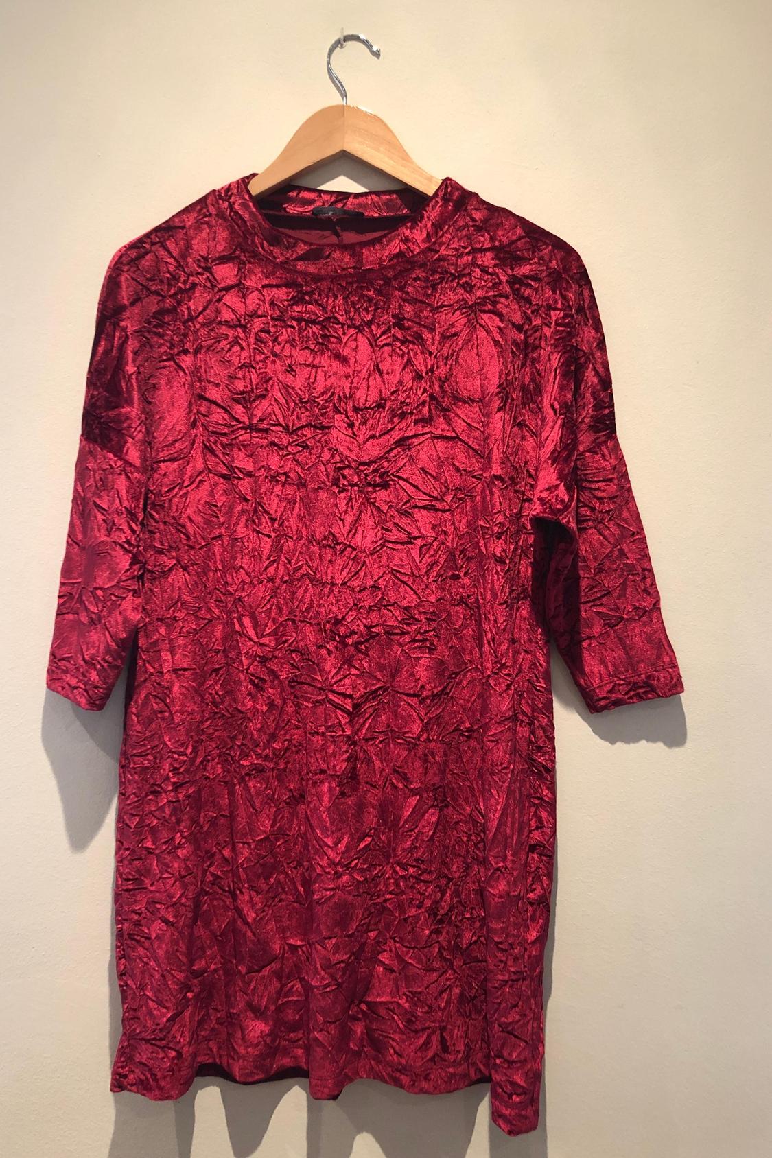Front view of a red t-shirt with a crinkled texture and three-quarter length sleeves.
