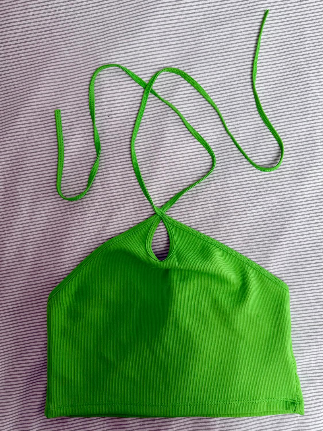 Front view of a green top with a halter neck and chest cut-out.