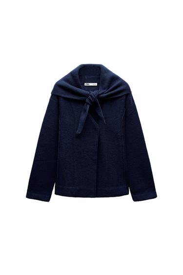 Front view of navy jacket with bow at the neck.