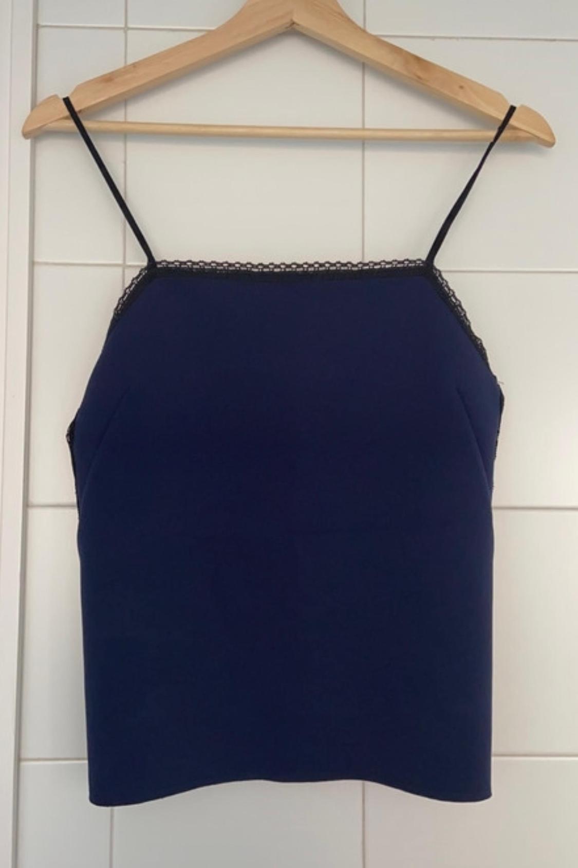 Front view of a blue top with spaghetti straps and lace detail on the top edge.
