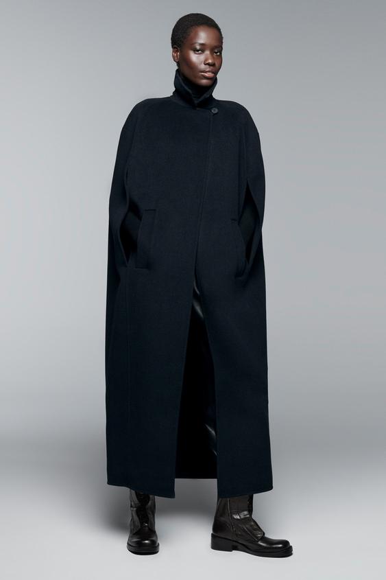 Souprava tmav modrho oversize plt s klopovm lmcem, pl᚝ovmi rukvy a pednmi kapsami. Zapnn vpedu na skryt knoflky.