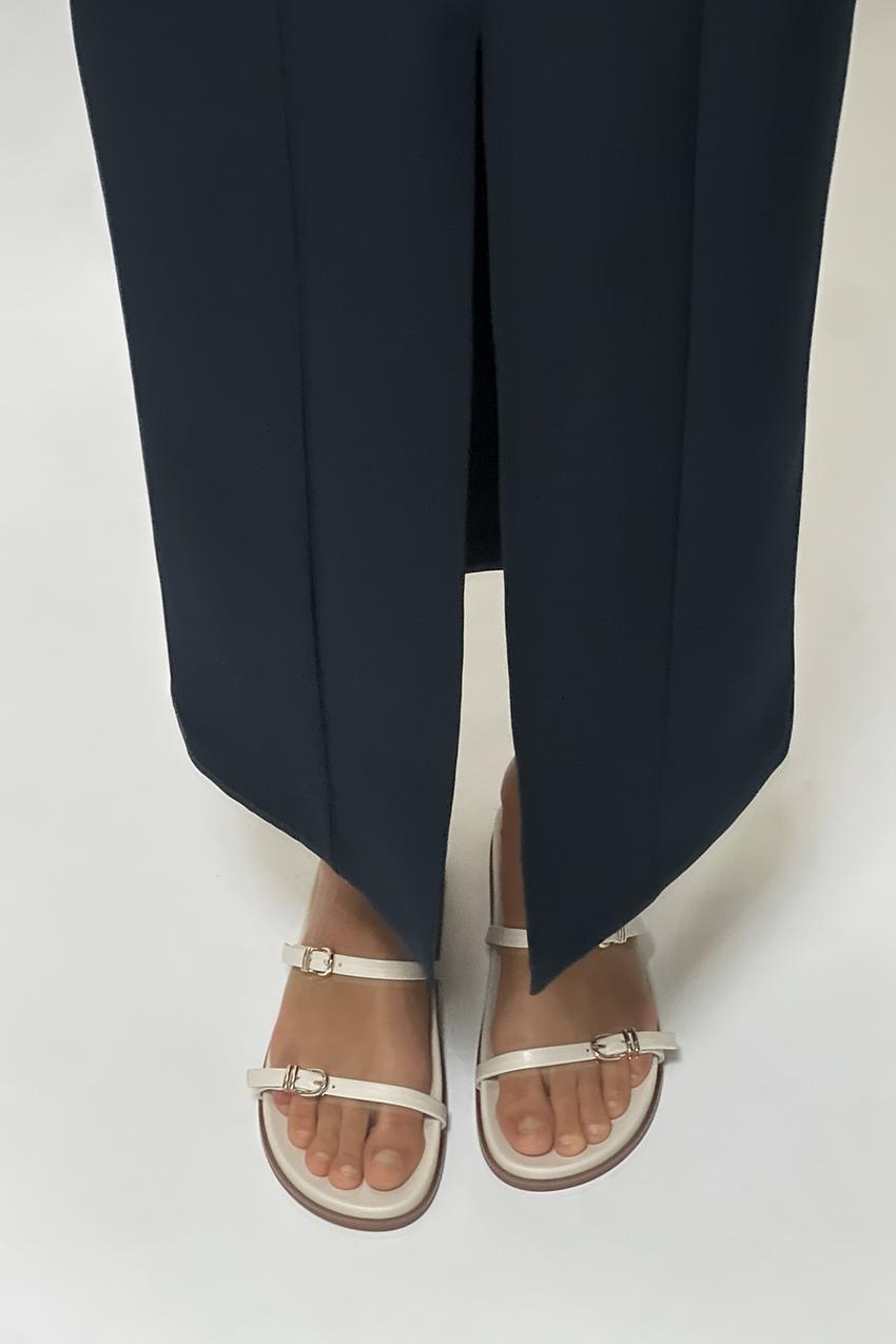 Zara minimal white flat sandals with thin buckled straps.