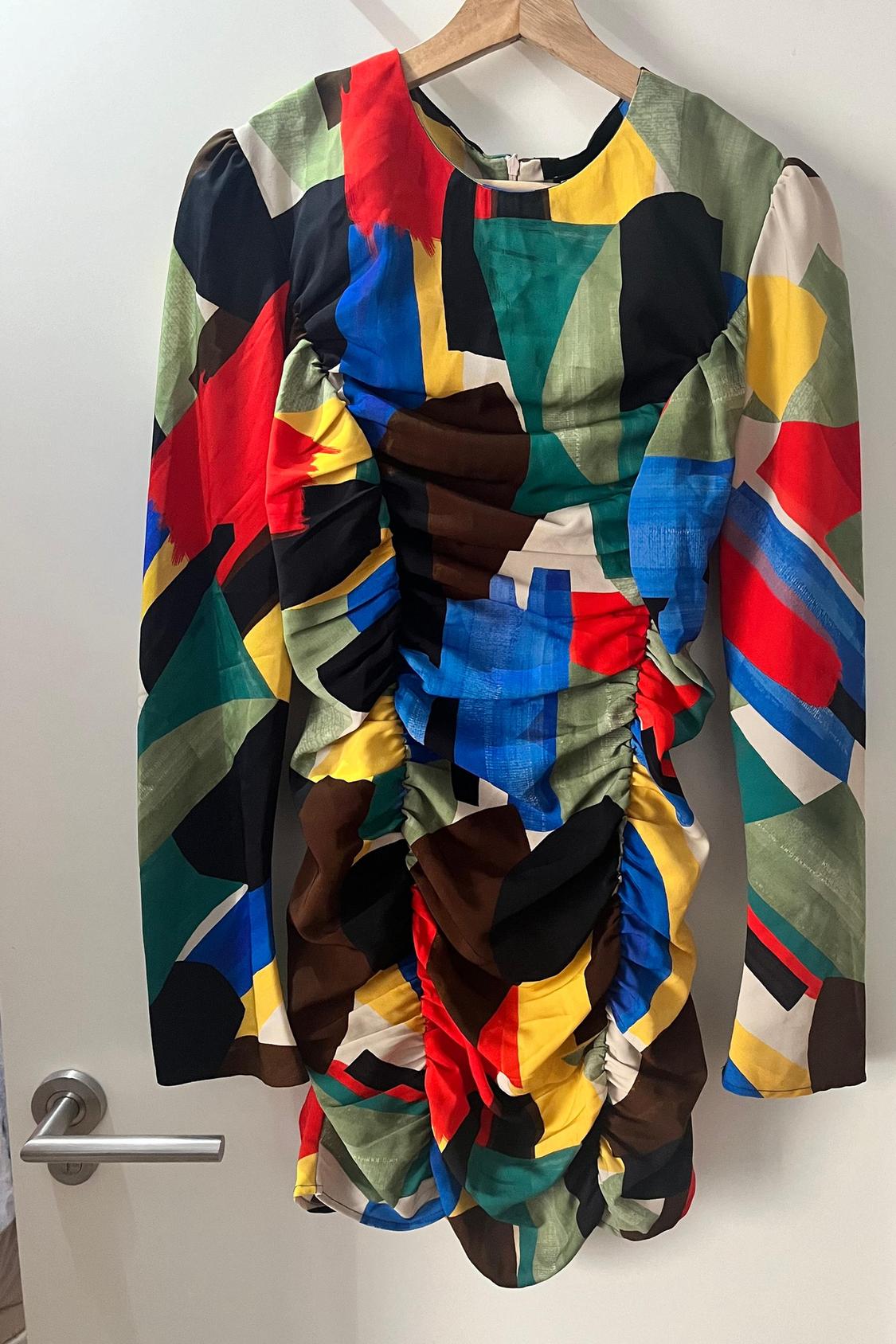 Front view of dress with multi-coloured abstract print and ruching at the front.