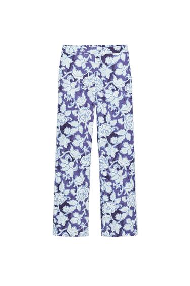 Straight-leg long trousers with a floral print in white and sky-blue tones on a dark-blue background.