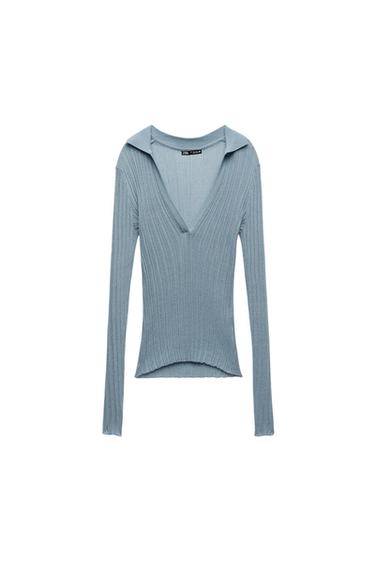 Blue long-sleeve V-neck sweater with ribbed texture. White background. Visible tag on the collar.