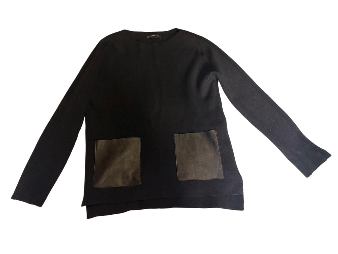 Black, long-sleeved jersey with two front pockets made from contrasting material. White background.