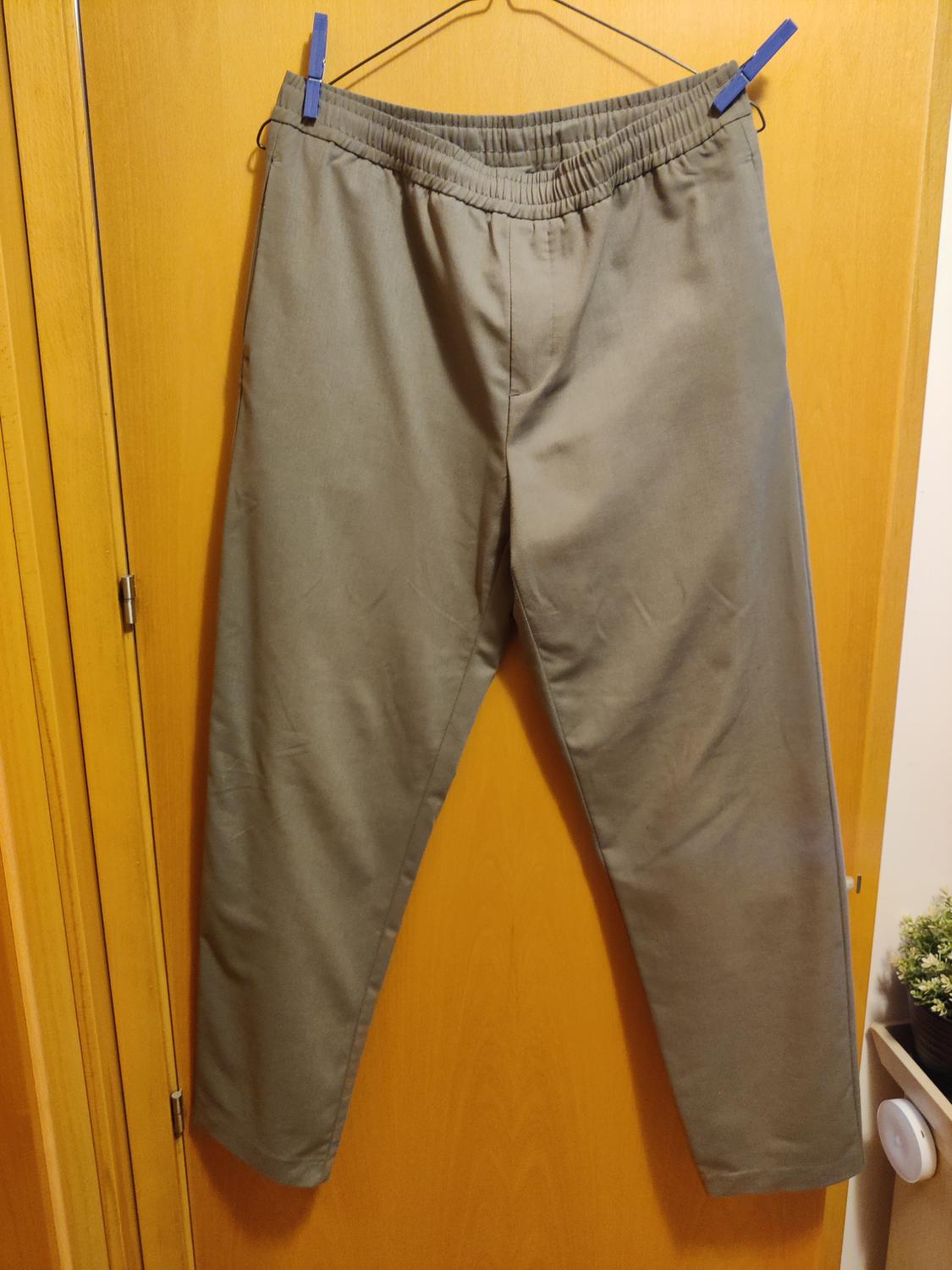 Front view of grey trousers with an elasticated waistband and no visible pockets.