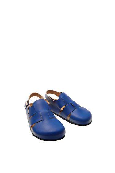 Blue intertwined design shoes with side buckle, on a white background.