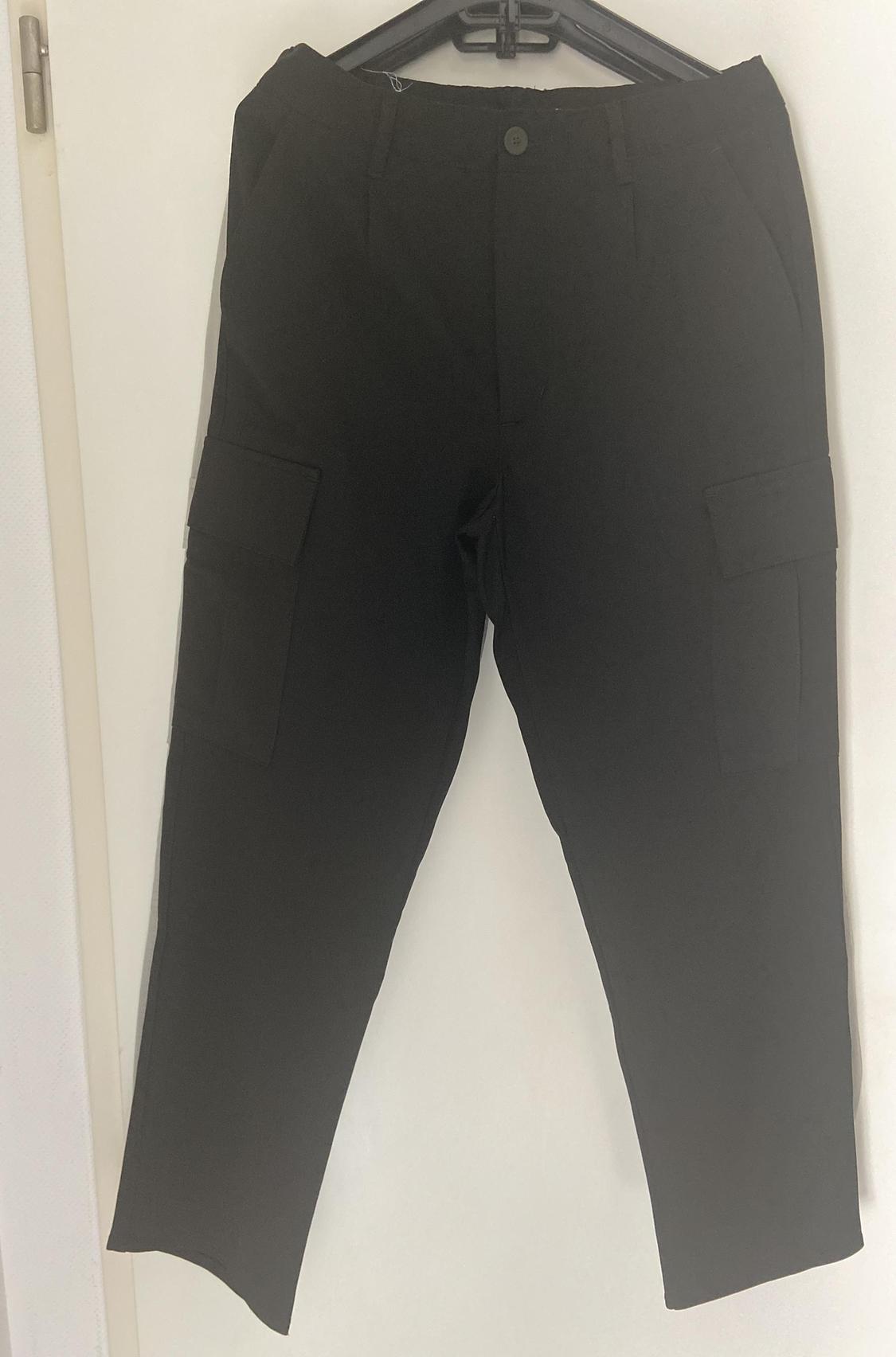 Front view of black trousers with side cargo pockets.