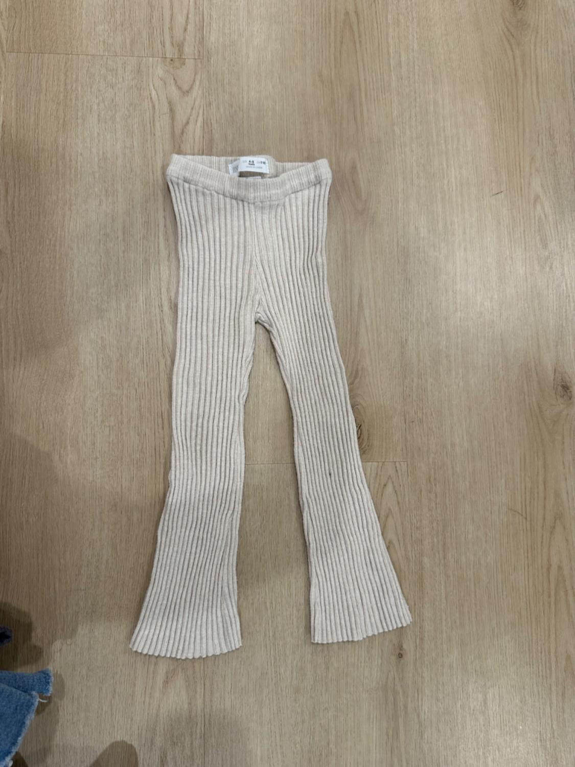 Front view of beige corduroy trousers for children.