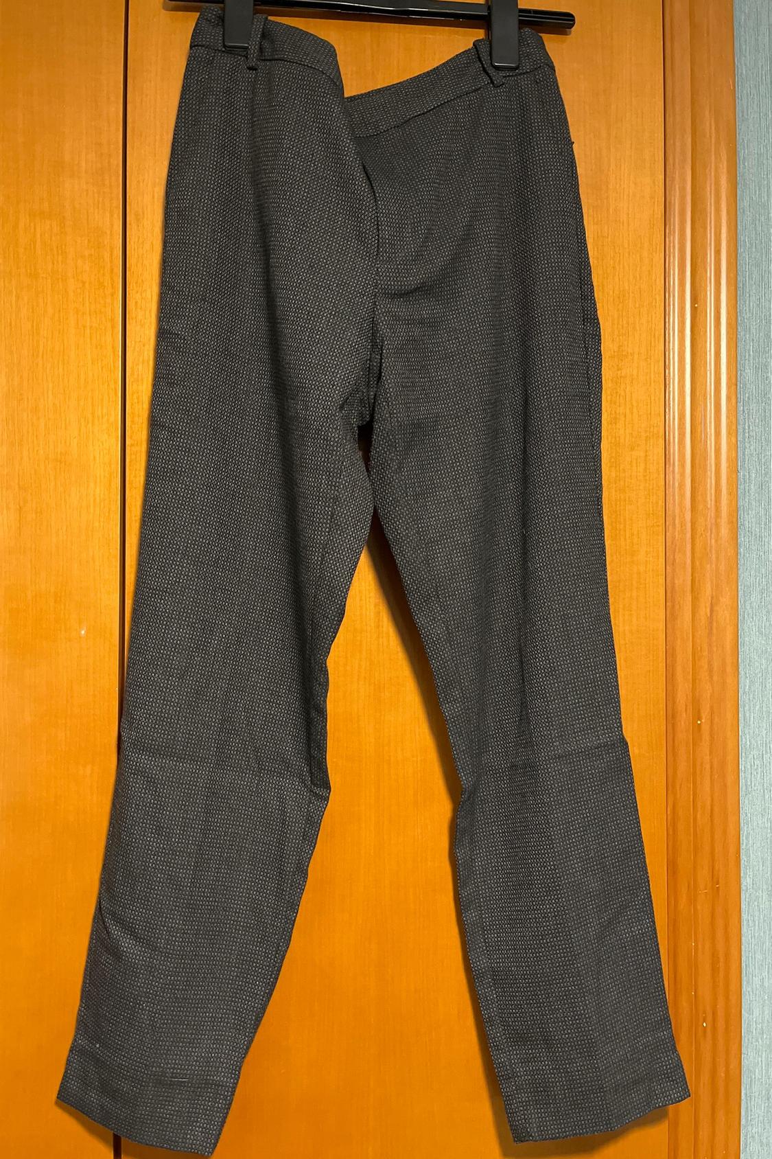 Front view of grey textured trousers with straight legs.