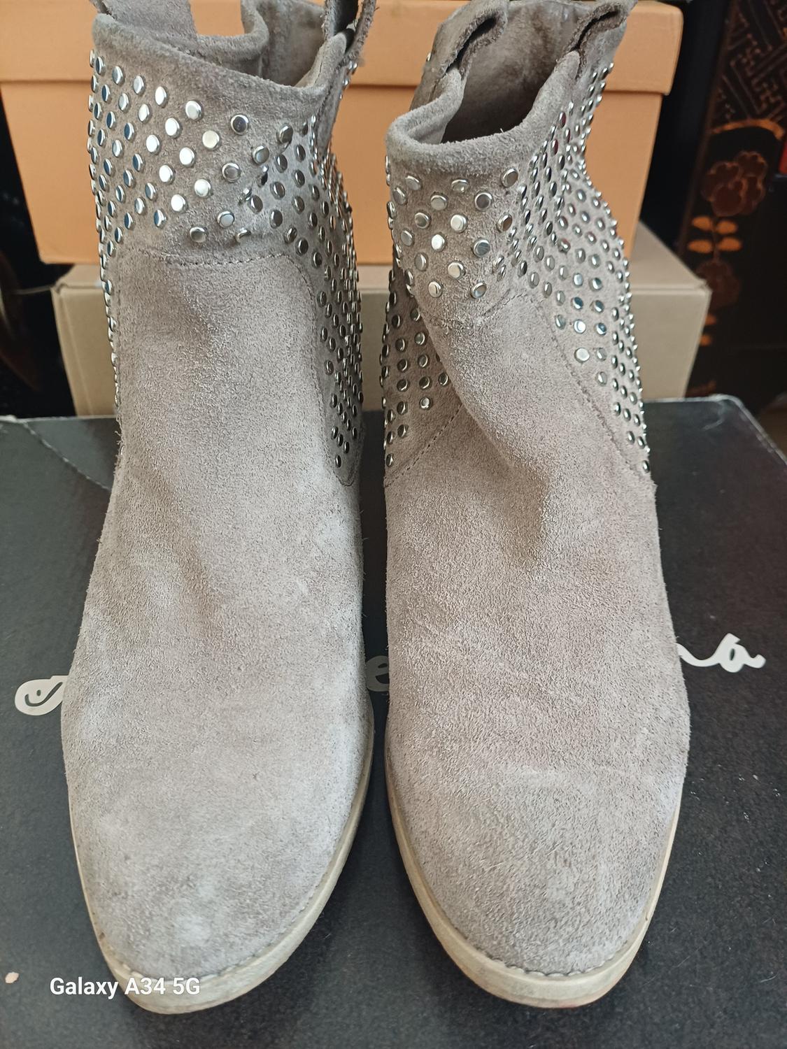 Front view of grey boots with metallic studs on the top.