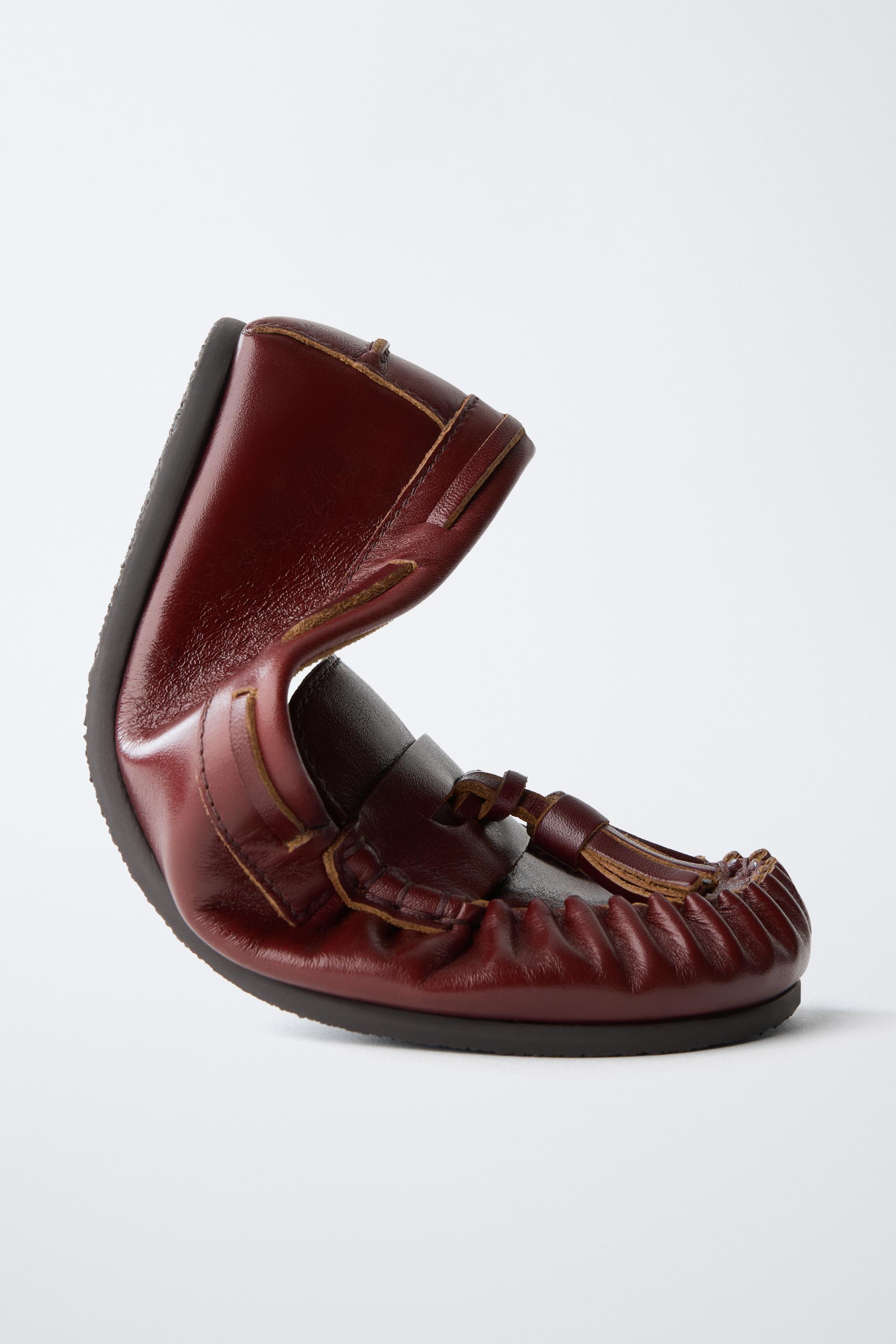 MOCASSINS EN CUIR À POMPONS