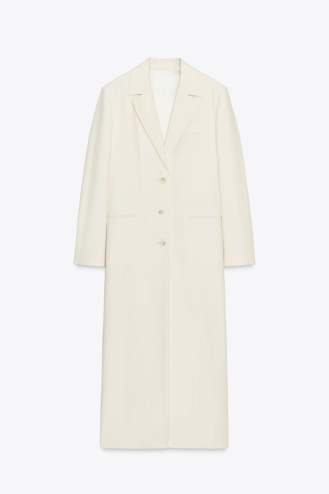 Front view of a long, raw-toned coat with a lapel collar, long sleeves, button fastening and front welt pockets.