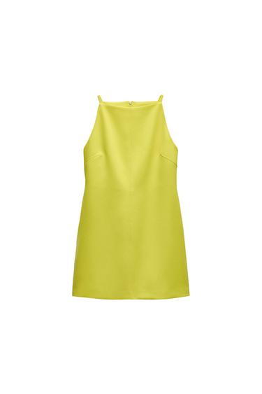 Yellow short dress with thin straps and a straight neckline with a central seam on a white background.