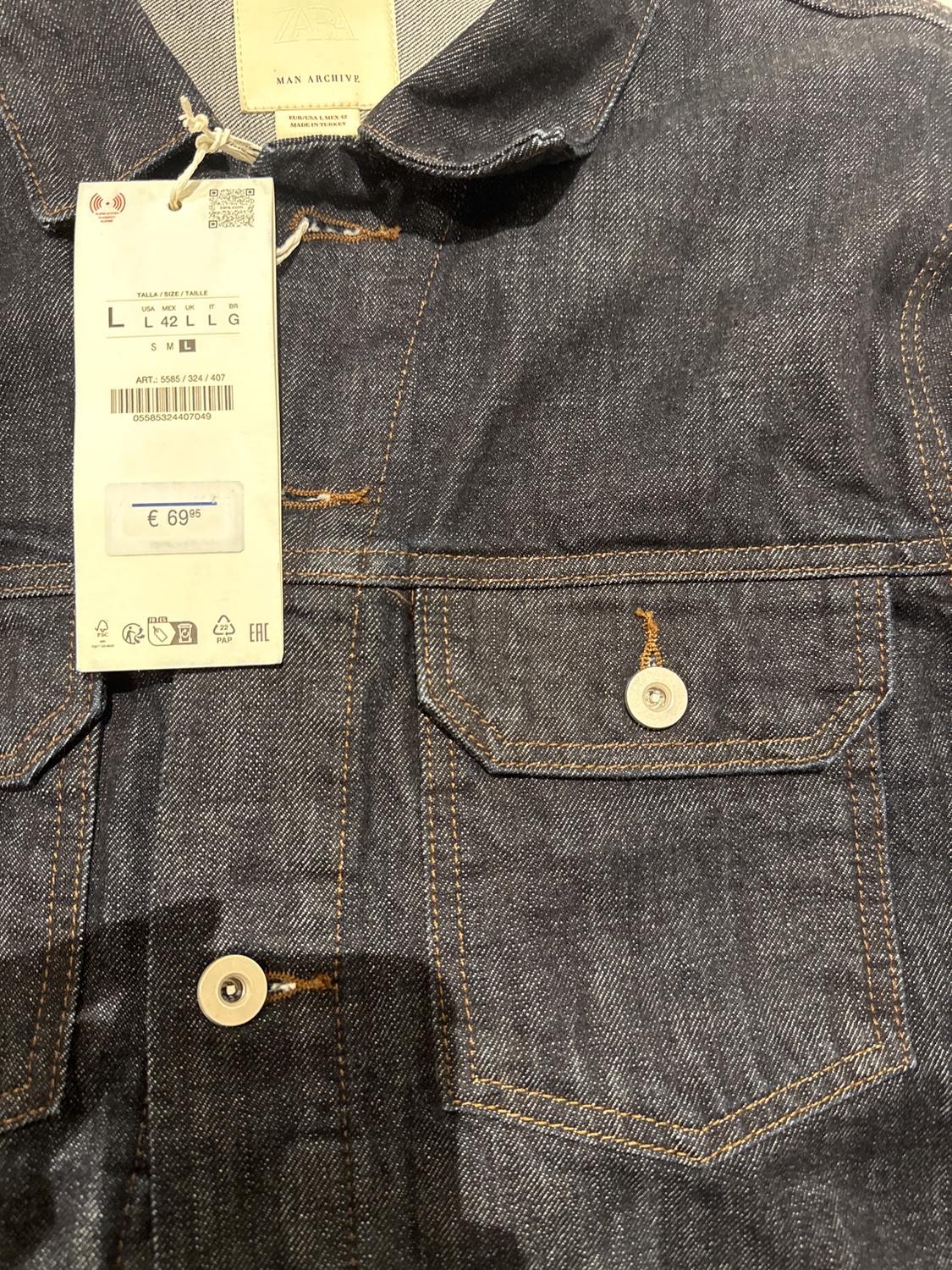 Blue denim jacket with price tag of €69.95. Button-up pocket and visible contrast stitching.