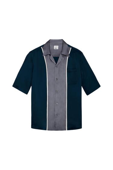 Front view of a blue and grey shirt with a pocket and buttons, detail of vertical white stripes.