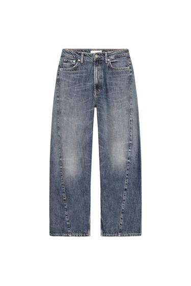 Front view of light blue baggy balloon jeans, mid-rise, five pockets, twisted seams, zip and button fastening.